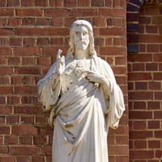 Statue of Jesus in front of a brick building