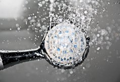 A shower head with water coming out of it. 