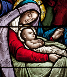 A stained class depiction of baby Jesus and the Virgin Mary 