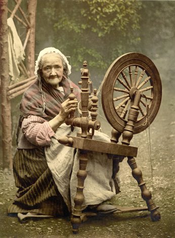 Elderly woman at spinning wheel