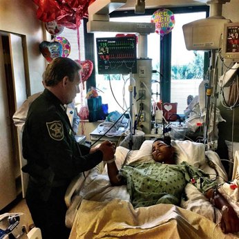 A police officer visits a shooting survivor in the hospital