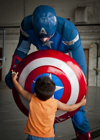 Captain America with a little boy holding his shield 