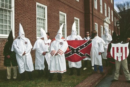 Ku Klux Klan members standing outside of a building