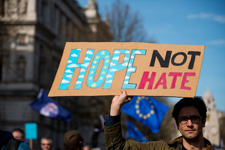 A man holds a Hope Not Hate sign