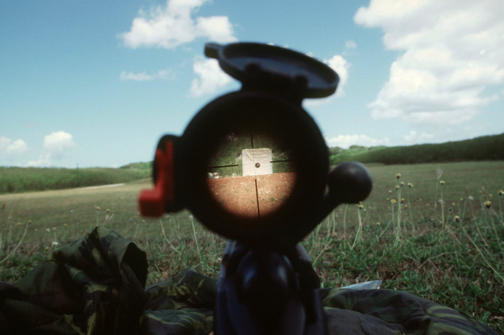 Looking through a gun at a target
