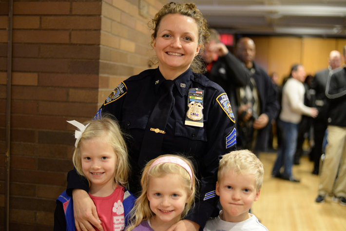 Smiling policewoman with three cute children