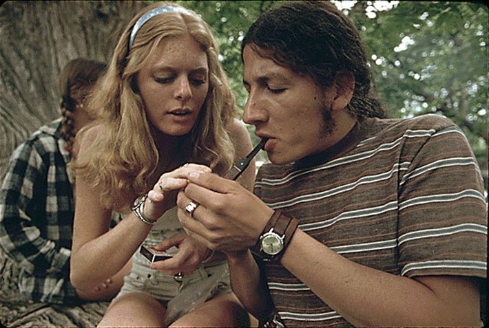 A man and a woman with a pipe smoking marijuana