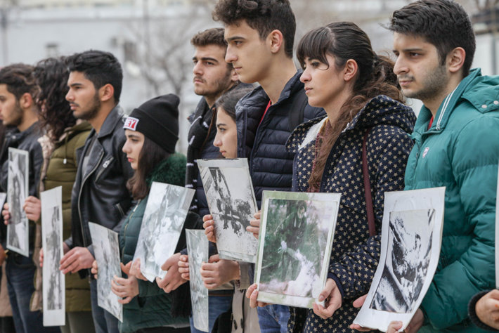 Azerbaijani tudents holding pictures of those who died in a genocide