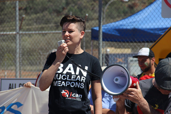 A woman in an ICAN t-shirt speaking through a megaphone