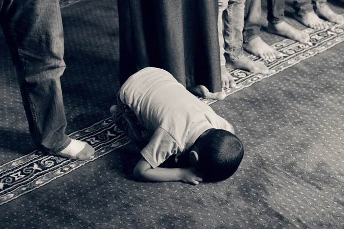 Boy kneels in prayer