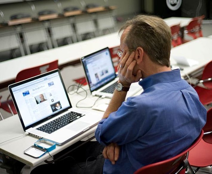 Man reading news on lap top