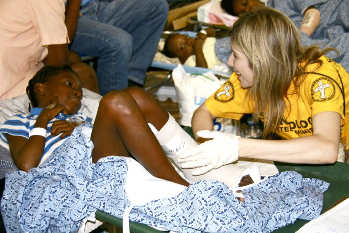 A Scientology Volunteer Minister helping a girl with a cast