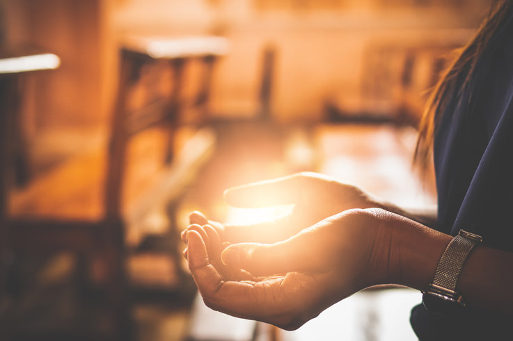 Close-up on woman's hands praying at church