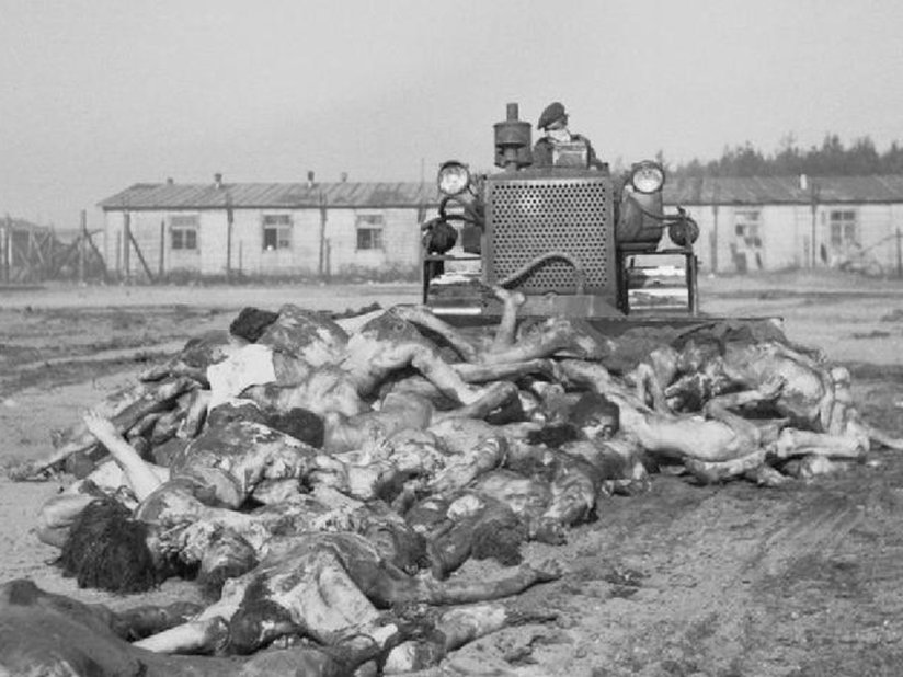 Bodies being pushed into a mass grave