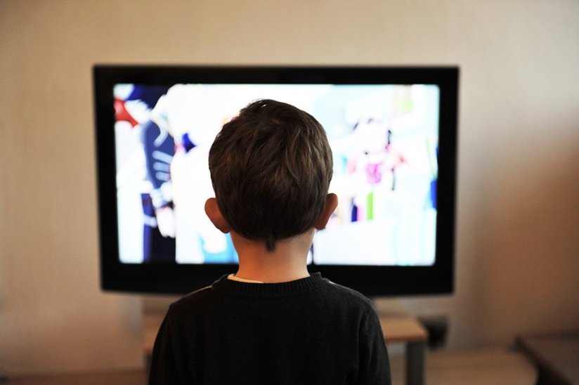 A little boy in front of a television set.