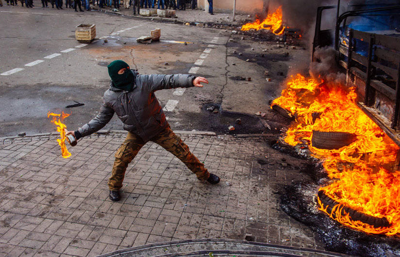 Man throwing a bottle lit on fire