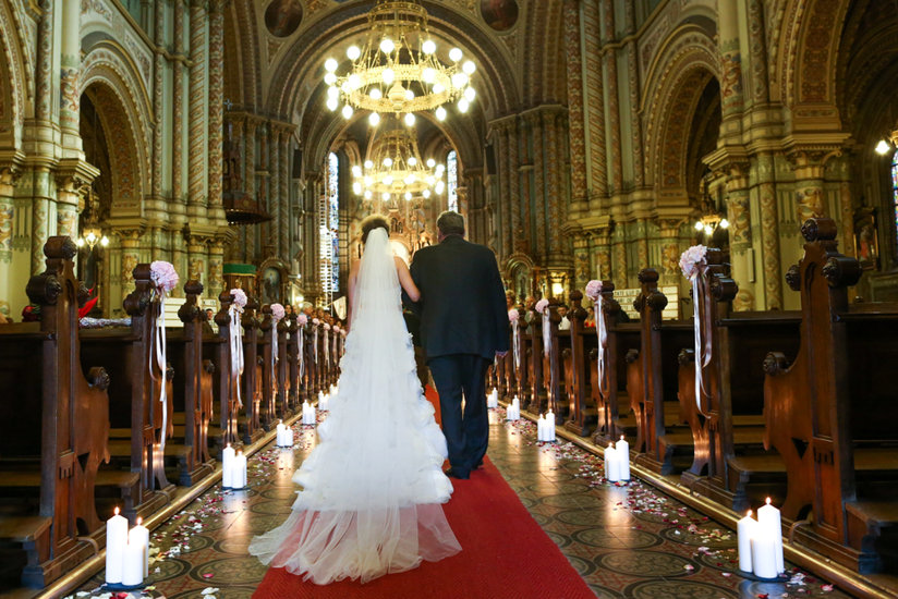Bride and father walking down the aisle in a church