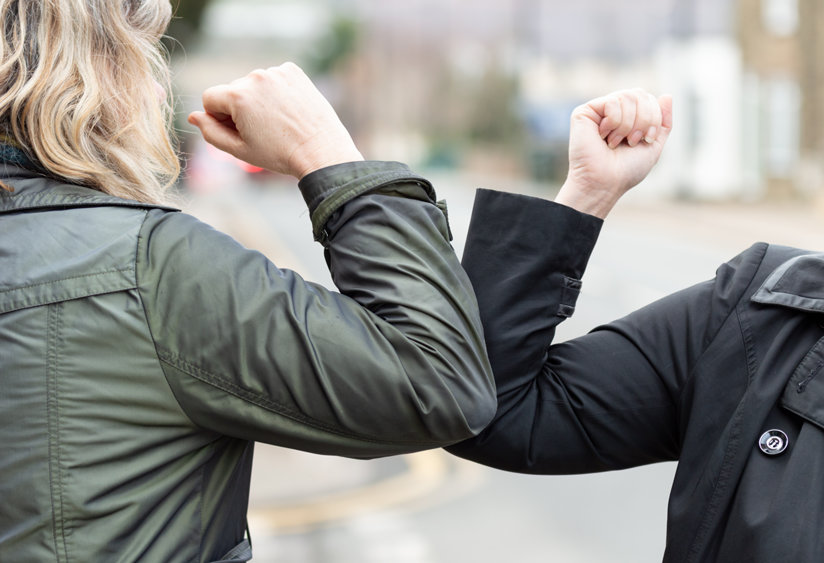 Two people touching elbows