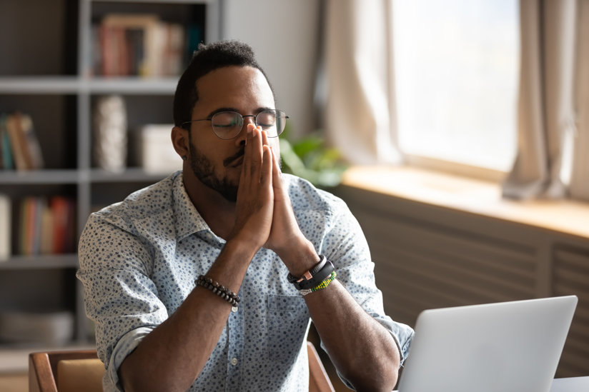 Man praying at computer