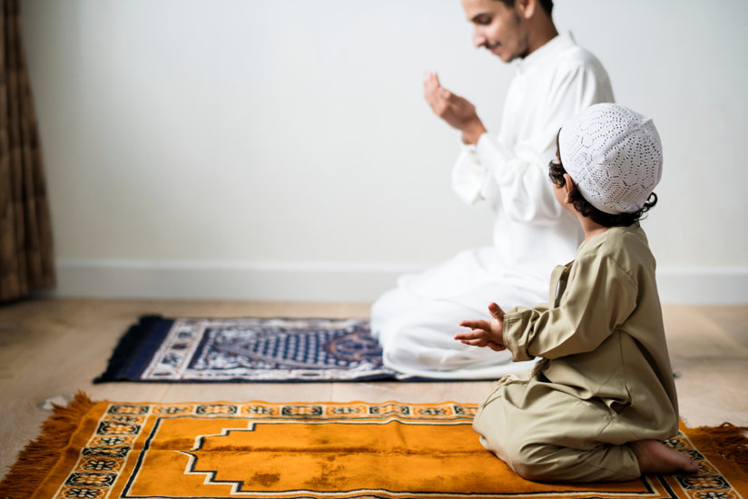 Child and adult on prayer mats