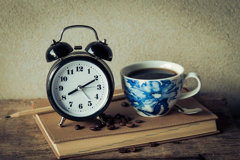An alarm clock and a coffee cup
