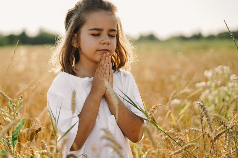 Girl in field praying