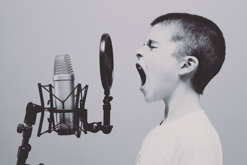 A boy shouting into a microphone