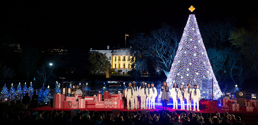 A Christmas performance in front of the White House with a large Christmas tree